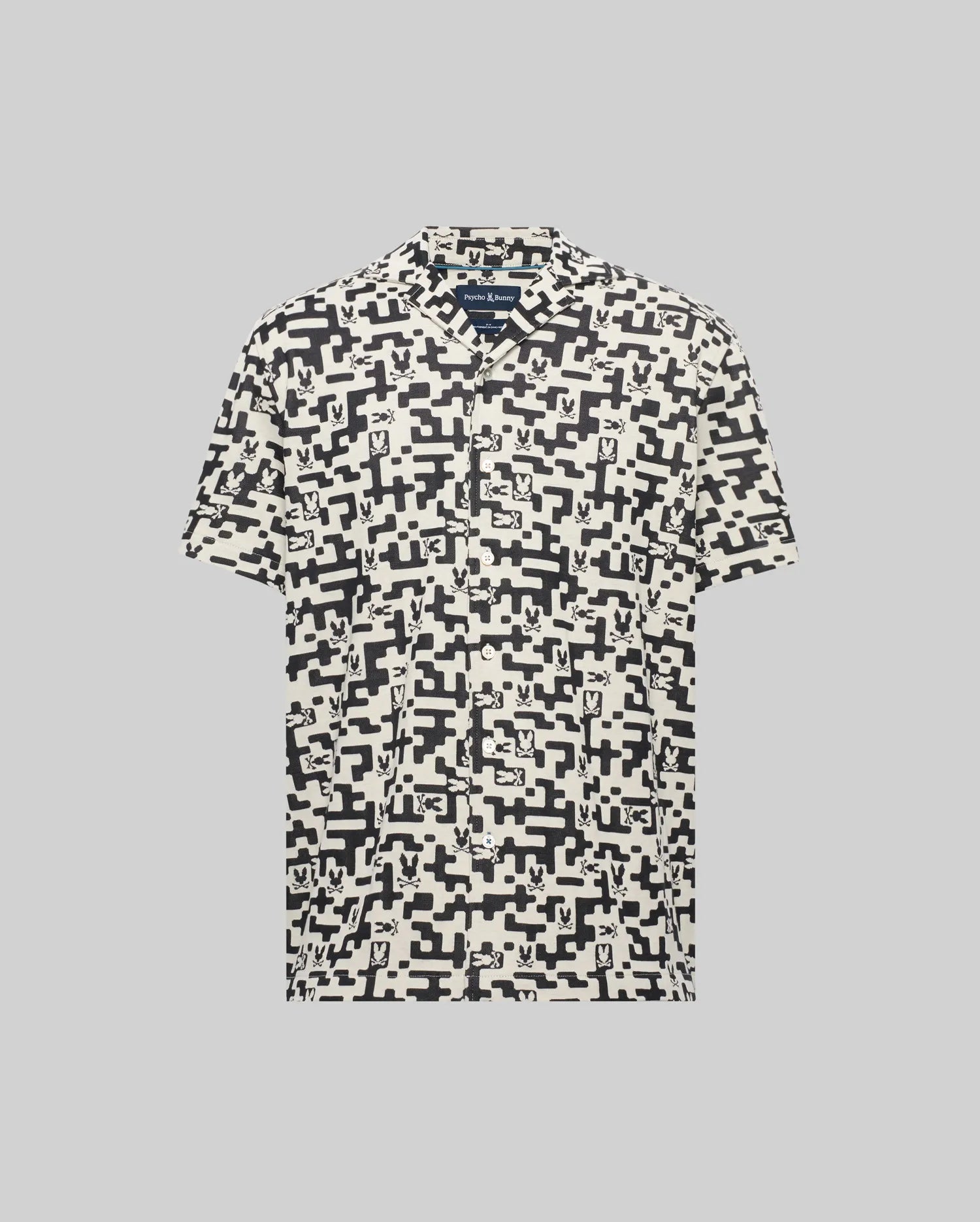 Mens Josh Jacquard Shirt, a cream short-sleeve button-up with a black all-over pixelated geometric pattern featuring integrated Psycho Bunny skull logos, in a relaxed fit.