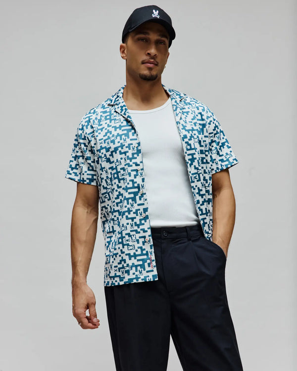 Mens Josh Jacquard Shirt: Relaxed fit white short-sleeve camp collar shirt featuring an all-over teal geometric and small Psycho Bunny skull logo pattern.