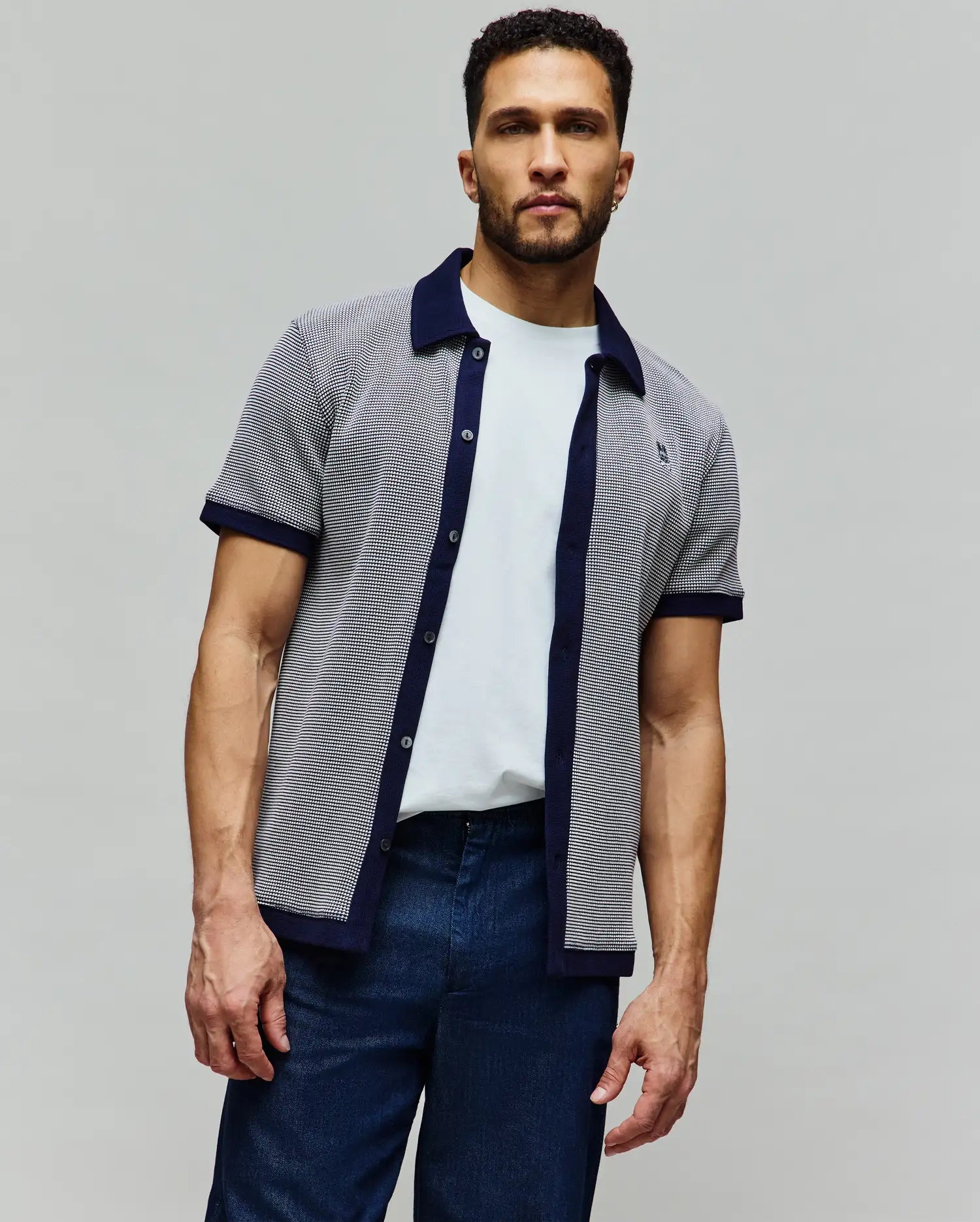 Mens Maxton Waffle Shirt, a classic fit short-sleeve knit shirt in navy and white micro-patterned waffle fabric with solid navy collar, placket, and cuffs, featuring a small embroidered Psycho Bunny skull logo on the left chest.
