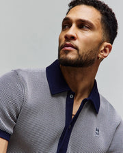 Mens Maxton Waffle Shirt, a classic fit navy and white two-tone waffle knit polo with solid navy collar, placket, cuffs, and an embroidered Psycho Bunny skull logo on the left chest.