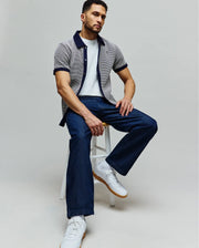 Mens Maxton Waffle Shirt, a classic fit short-sleeve collared shirt in a light grey waffle knit with navy blue collar, placket, and cuffs, featuring a small embroidered Psycho Bunny skull logo on the left chest.