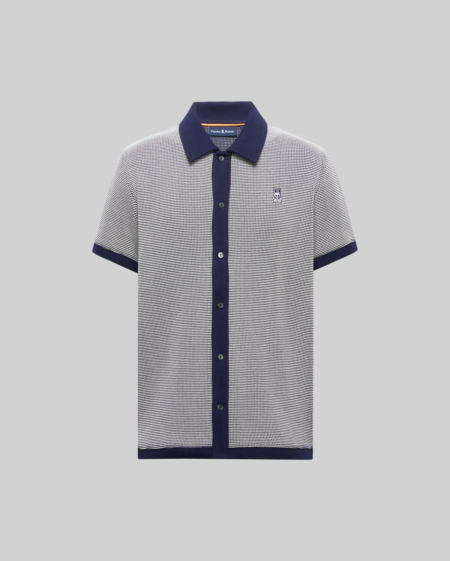 Mens Maxton Waffle Shirt, a classic short-sleeve polo in navy/white micro-pattern waffle knit, solid navy collar, placket, cuffs, hem, and embroidered Psycho Bunny skull logo on left chest.