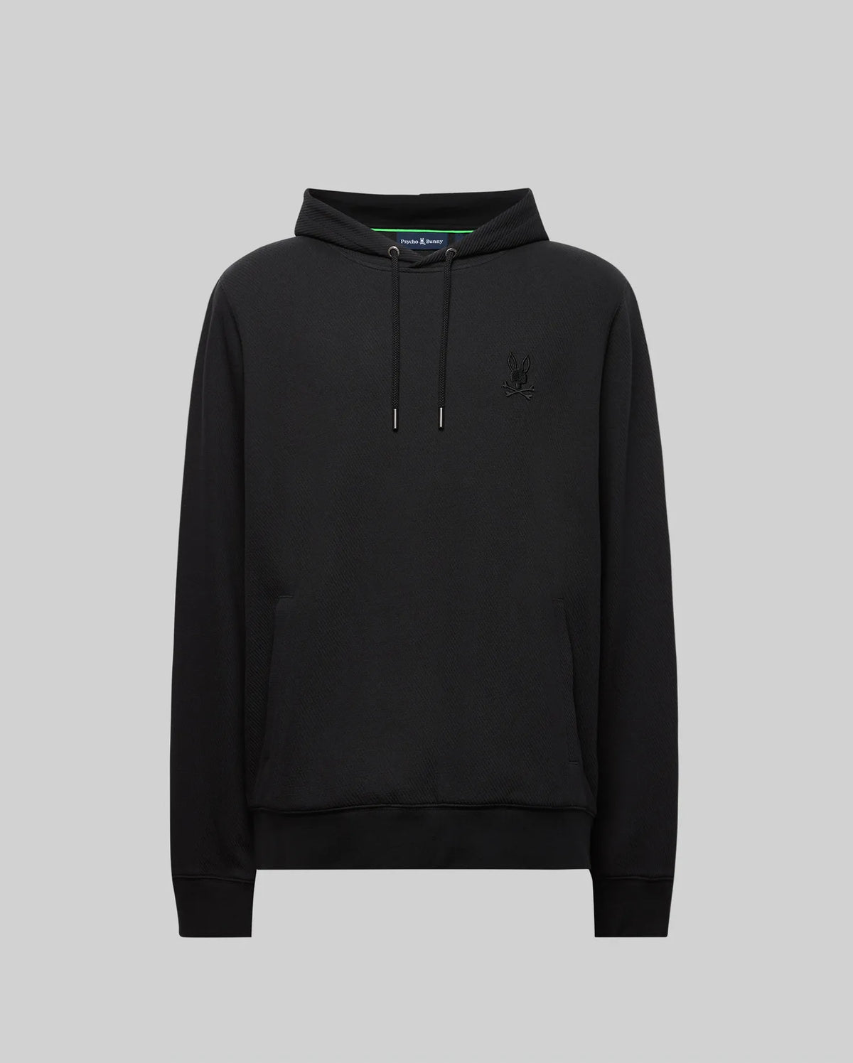 The Psycho Bunny MENS KAI HOODIE - MT0500019 is a plain black hoodie with a twill-textured finish, small embroidered Bunny logo on the left chest, front pouch pocket, and drawstrings, shown on a light gray backdrop.