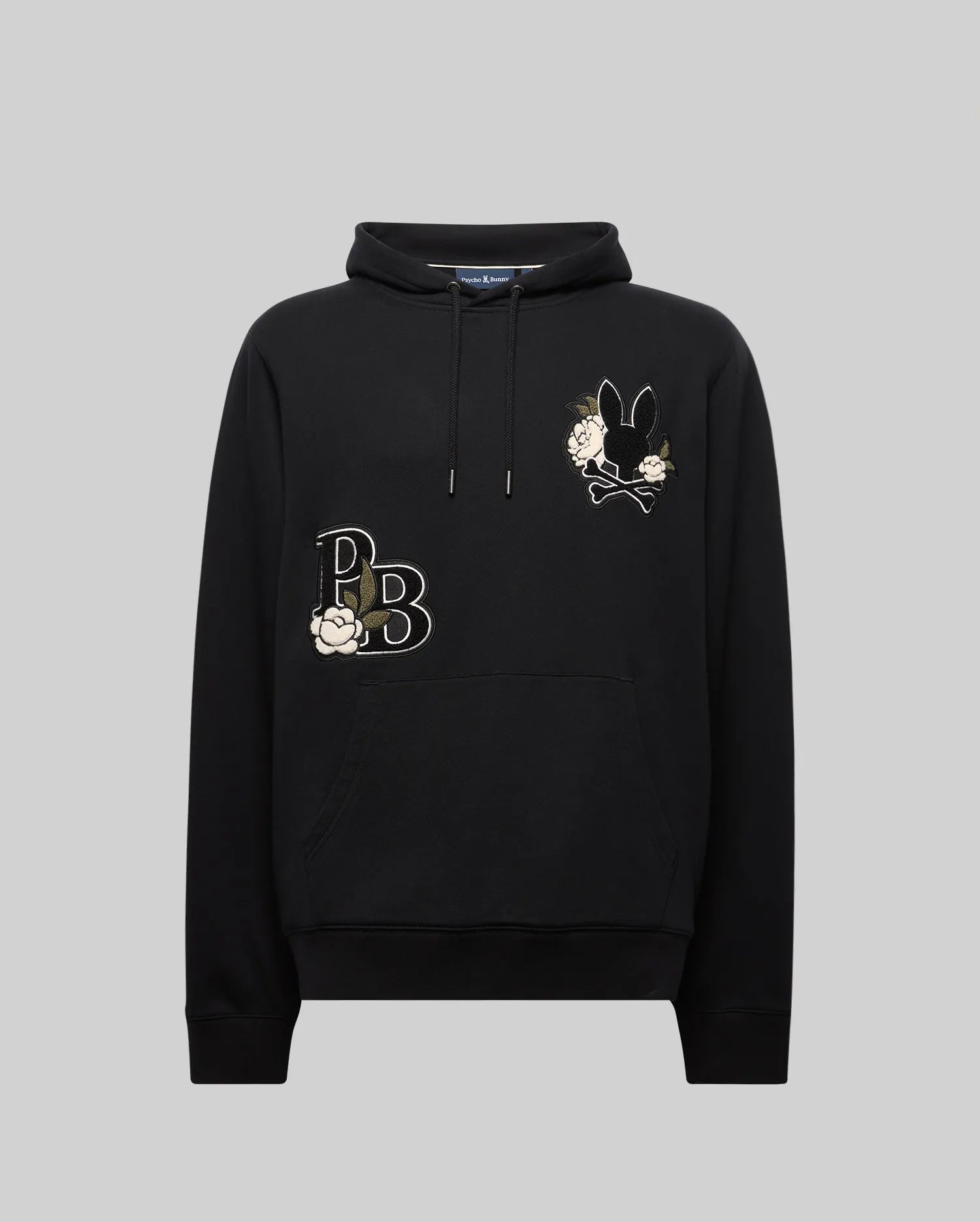 The MENS AUGUSTE HOODIE - MT0500043 by Psycho Bunny is a premium cotton regular fit hoodie with a front pocket, white flower embroidery, "PB" on the left chest, and a black bunny holding flowers on the right chest. Displayed on gray.
