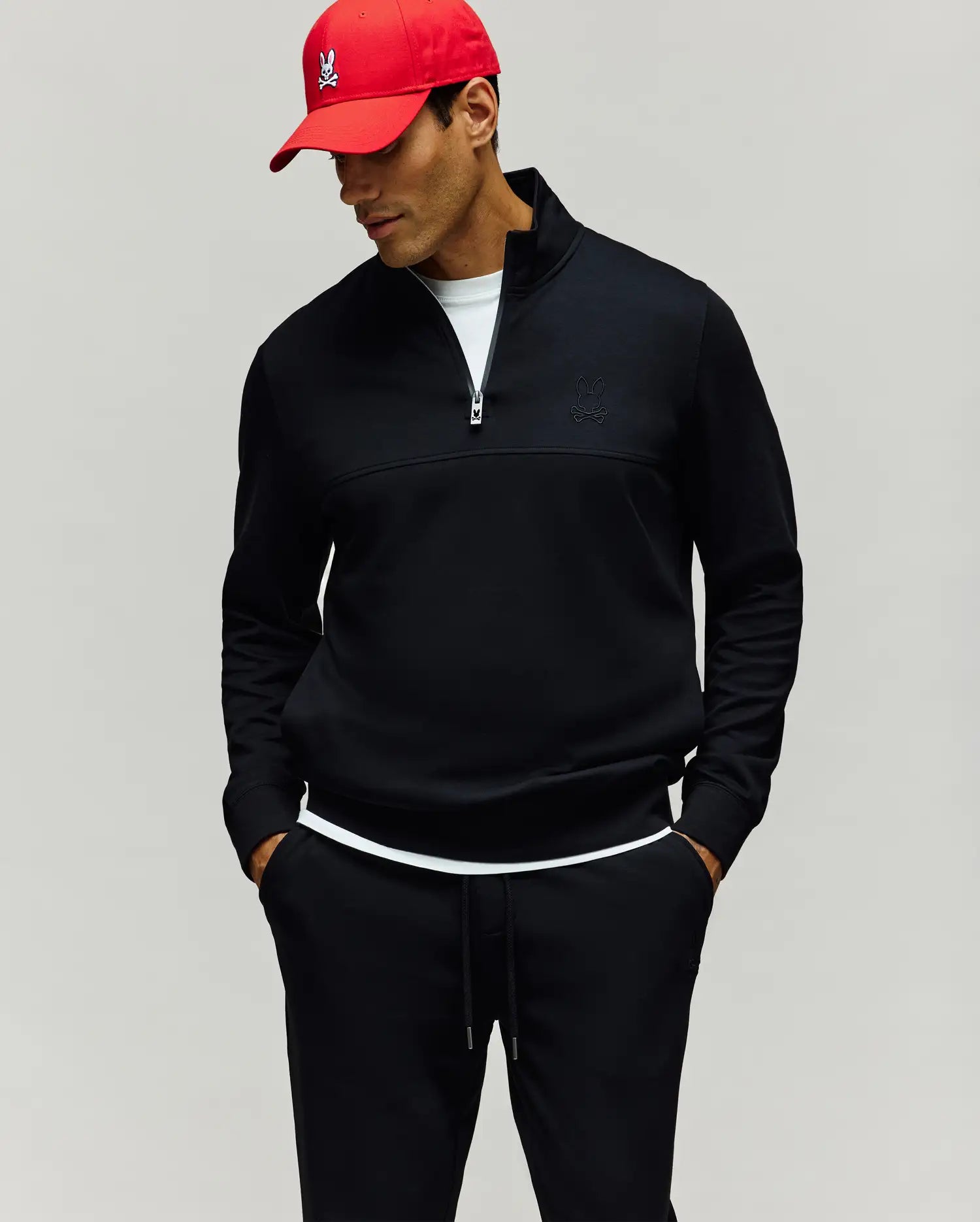 Mens Zeke 1/4 Mock Zip Pullover. Black classic fit smooth knit pullover featuring a 1/4 zip, stand collar, and a subtle tone-on-tone embroidered Psycho Bunny skull logo on the left chest.