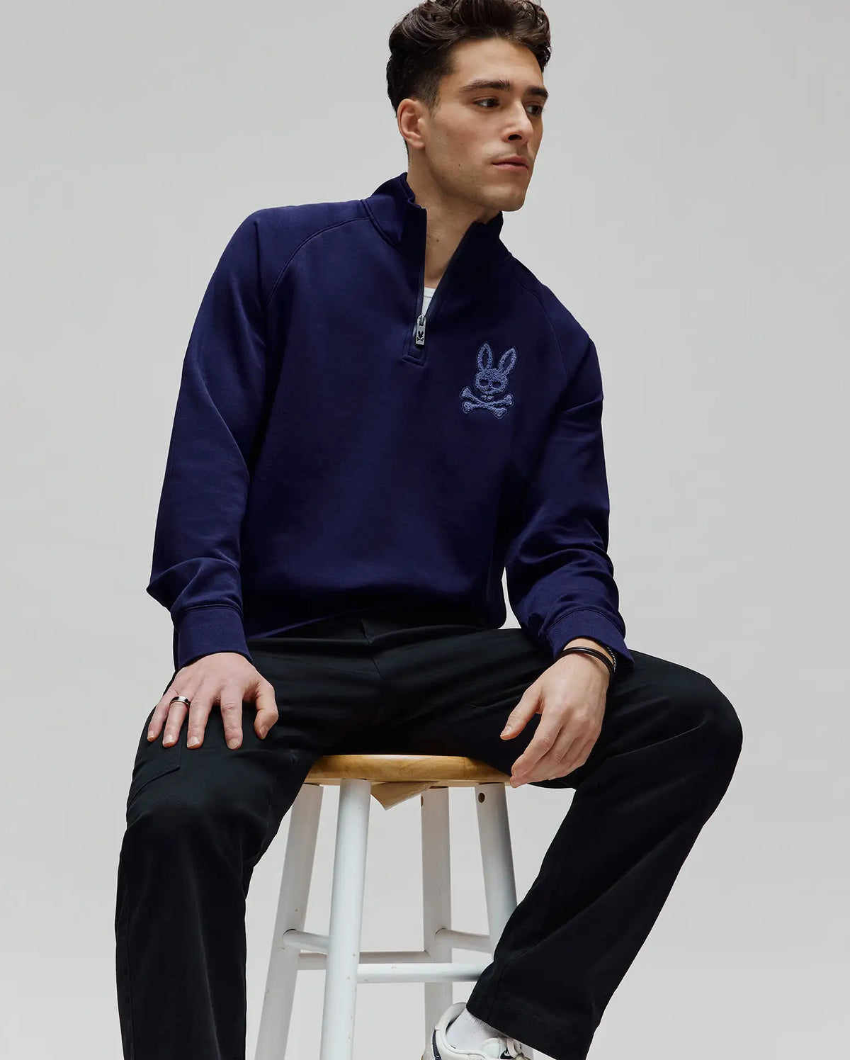 Mens Tate 1/4 Zip Chenille Pullover in navy blue french terry, featuring a classic fit, stand collar, silver 1/4 zip, and a prominent light blue chenille bunny skull logo embroidered on the left chest.