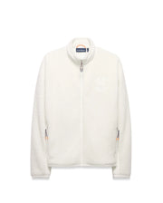 Men's Rowley Sherpa Zip Jacket, a cream-colored full-zip jacket with a soft sherpa texture, features a large embroidered Psycho Bunny skull logo on the left chest and orange/navy accent zipper pulls. (6)