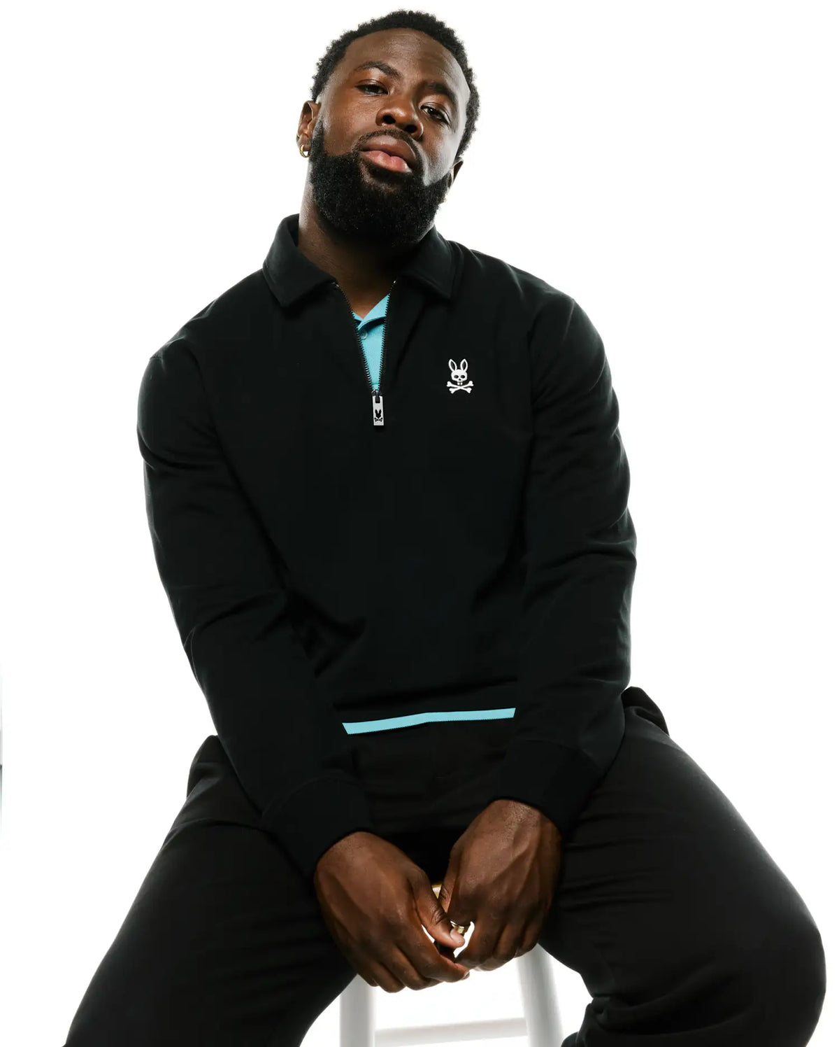 Black classic fit Men's Samson Quarter-Zip Sweater in a smooth knit, featuring a light blue inner collar, quarter-zip with logo pull, and small white embroidered Psycho Bunny skull on the left chest. (4)