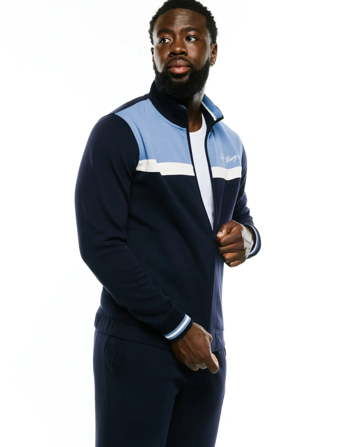 Men's Jacques Pique Track Jacket in navy with light blue and white color block panels, full zip, ribbed cuffs, and an embroidered Psycho Bunny script logo on the left chest. (3)
