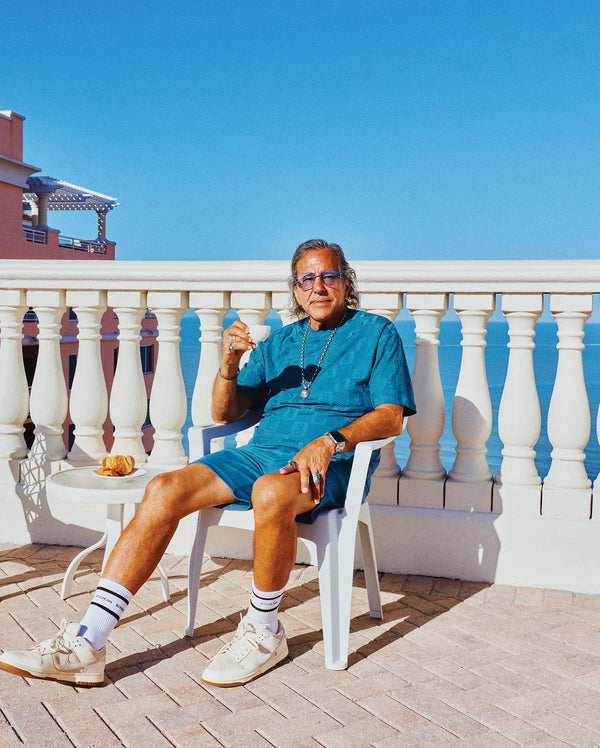 Mens Dustin Oversized Tee in vibrant teal blue with a subtle geometric textured knit, paired with matching relaxed fit shorts and white crew socks featuring black Psycho Bunny branding stripes.