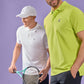 Two men in sportswear, one in a white cap and a Psycho Bunny Pima cotton polo (MENS CLASSIC POLO - B6K001ARPC), holding a tennis racket, and the other in a green polo, smiling, against a purple background.