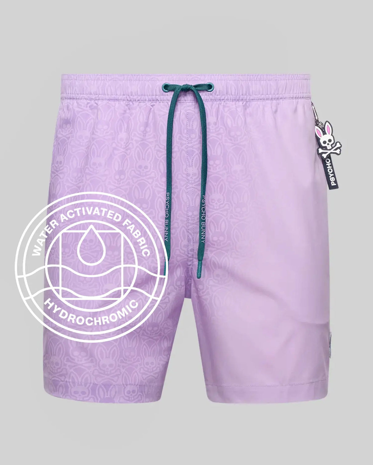 Mens Samos Hydrochromic Printed Swim Trunk in lavender, with a water-activated bunny skull pattern, dark green Psycho Bunny drawstring, and an iconic bunny skull logo tag.