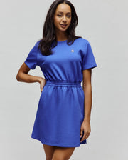 Womens Penelope Dress in royal blue jersey knit, featuring a relaxed fit, elasticated waist, and a small white, black, and pink embroidered Psycho Bunny skull logo on the left chest.