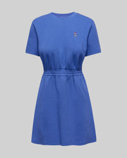 Womens Penelope Dress in vibrant blue jersey knit, featuring a relaxed fit, crew neck, short sleeves, cinched elasticated waist, and a small embroidered pink and white Psycho Bunny skull logo on the left chest.