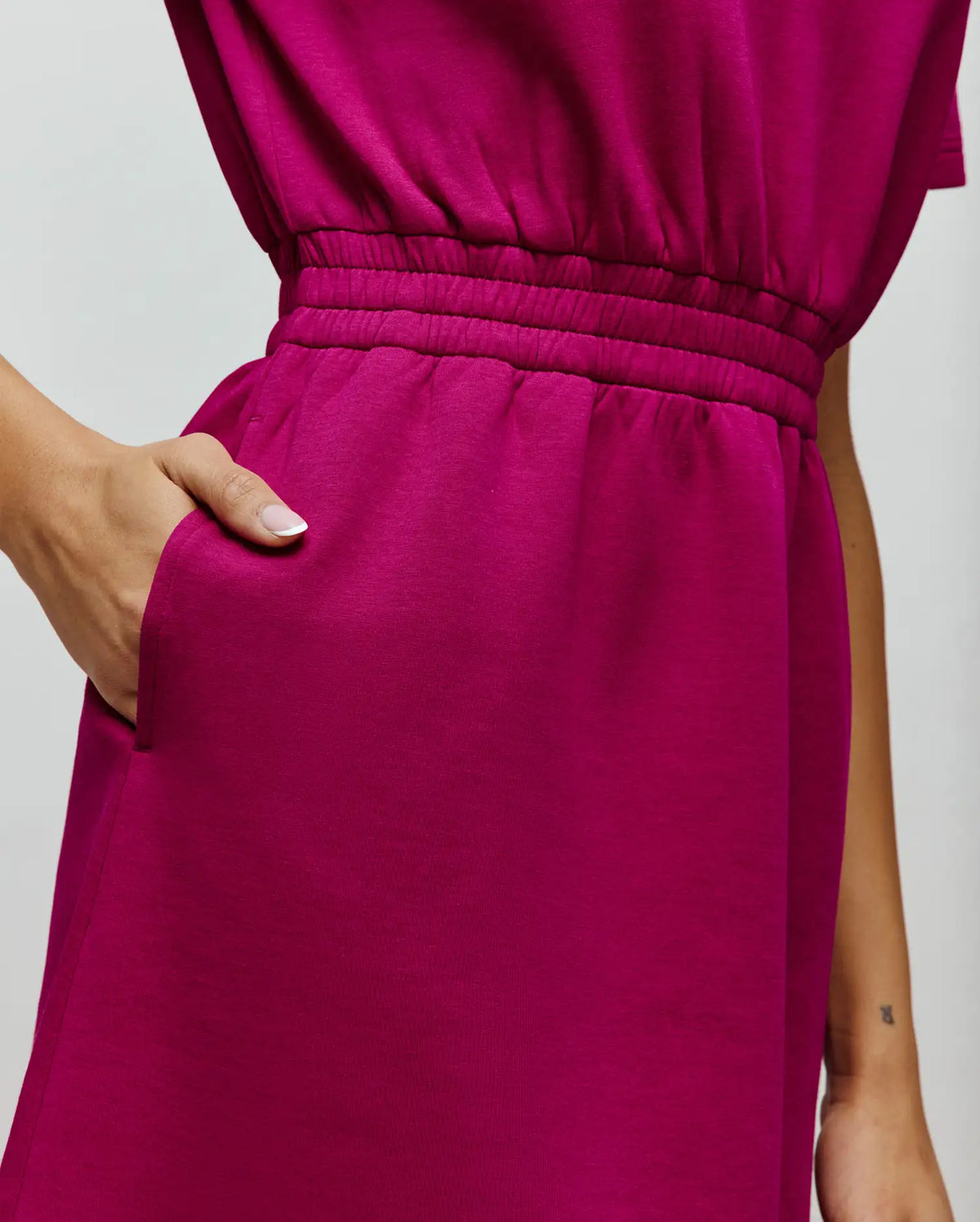 Vibrant magenta Womens Penelope Dress in soft jersey knit, featuring a comfortable elasticated waist and practical side pockets for a relaxed, modern fit.