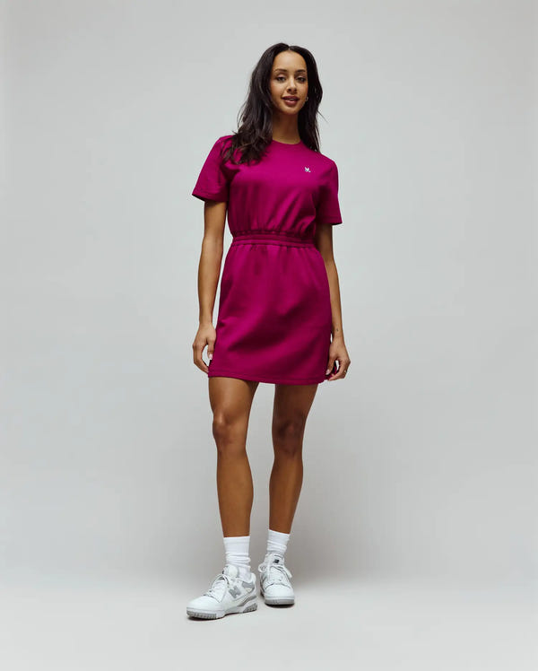 Womens Penelope Dress in vibrant magenta, featuring a relaxed fit, short sleeves, crew neck, and an elasticated drawstring waist, with a small white embroidered Psycho Bunny skull logo on the left chest, crafted from soft jersey fabric.