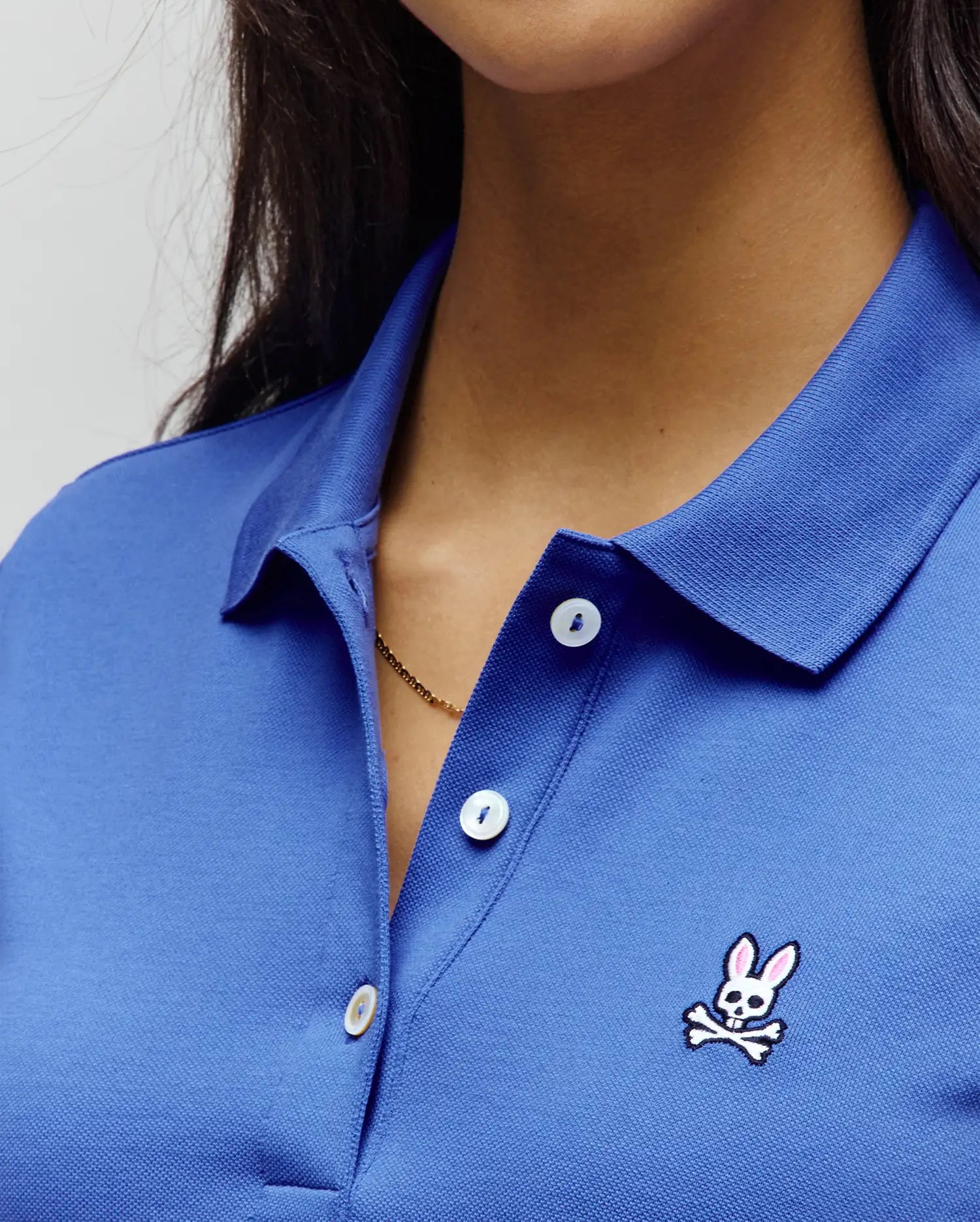 Women's Classic Pique Polo in royal blue, featuring a classic fit, textured pique fabric, white buttons, and a small embroidered pink and white Psycho Bunny skull logo on the left chest.