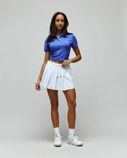 Women's Classic Pique Polo, a vibrant royal blue, features a slim, cropped fit in textured pique fabric with a two-button placket and a small embroidered white Psycho Bunny skull logo on the left chest.