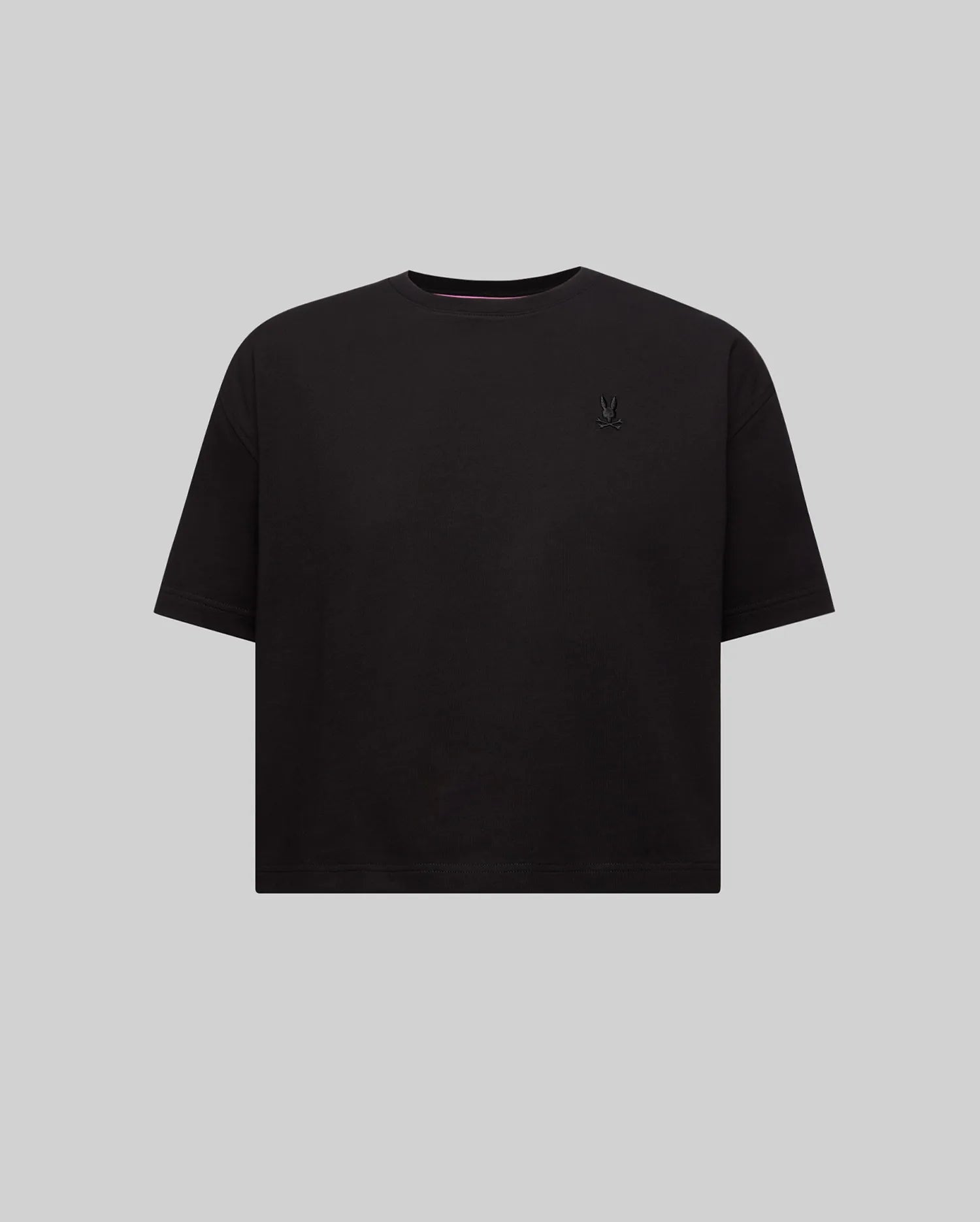 Women's Camille Oversized Fit Tee, a black oversized jersey knit t-shirt featuring a small embroidered black Psycho Bunny skull logo on the left chest and pink neck tape.