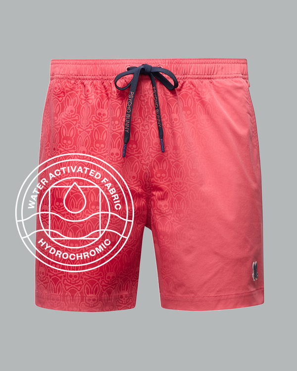 The Psycho Bunny MENS SAMOS HYDROCHROMIC PRINTED SWIM TRUNK (B6W453F200) features a navy drawstring, subtle pattern, small animal logo, and water-activated hydrochromic fabric highlighted by a droplet icon.