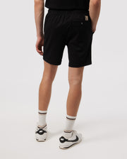 A man models Psycho Bunny's MENS WILLIS STRETCH TENCEL SHORT paired with white crew socks and black Nike sneakers, focusing on his lower half against a plain white background.