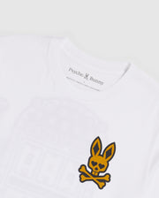 A close-up of a white Pima cotton jersey t-shirt with a yellow and black skull and crossbones logo featuring bunny ears on the chest. The inside label reads "Psycho Bunny" with a small printed bunny logo. The background is plain white. The product shown is the MENS VEGAS CITY TEE - B6U967X1PC by Psycho Bunny.