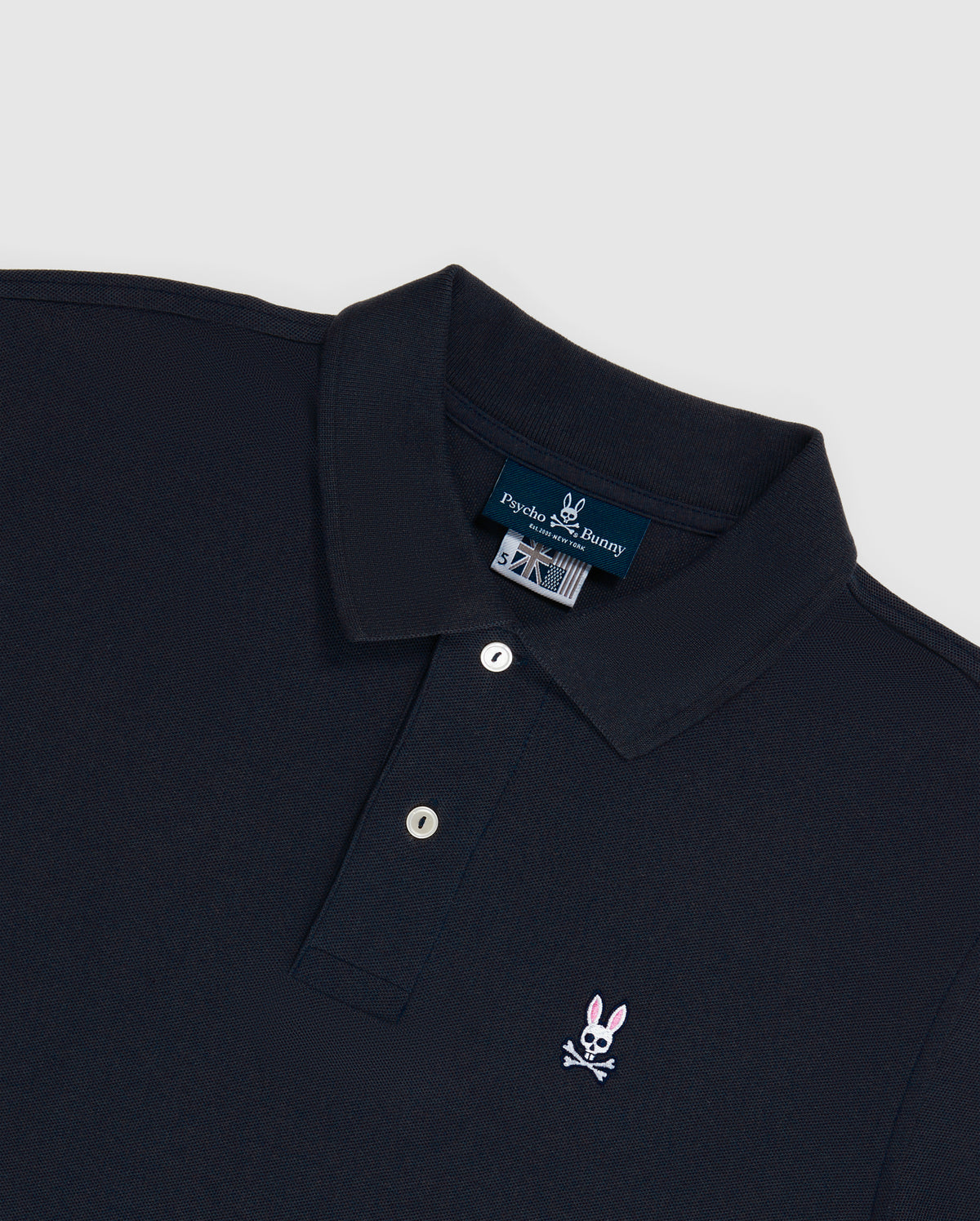The Psycho Bunny Men's Big and Tall Classic Piqué Polo Shirt (B9K001ARPC) is made from soft Pima cotton and features a collar, buttoned placket, and black diamond-knit piqué fabric with a small pink bunny embroidered logo with a skull on the left chest.